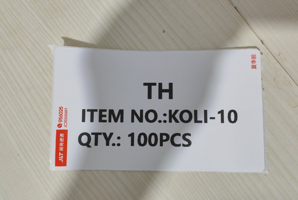 A carton mark label with TH / ITEM NO. KOLI-10 / QTY 100PCS printed on a thermal express waybill printer using J&T label paper