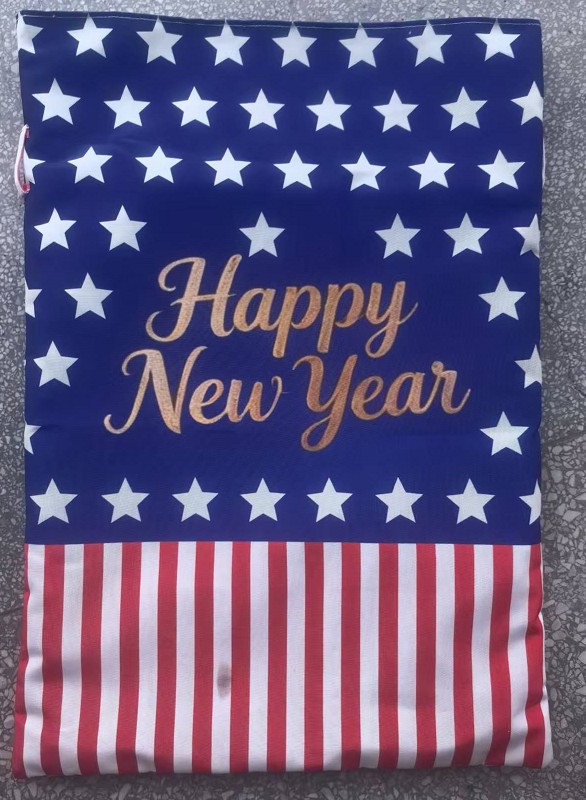 Physical sample of the New Year stars and stripes drawstring gift bag, navy with white stars, gold Happy New Year lettering and red and white striped base